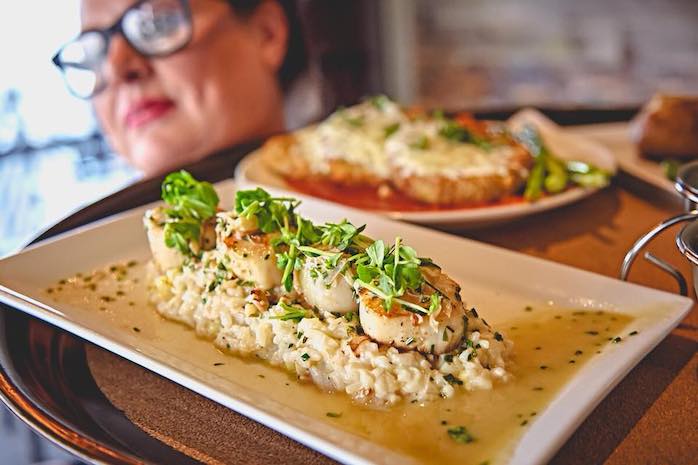 Pan-Seared Scallops With a creamy crab corn risotto & a drizzle of crab beurre fondue.